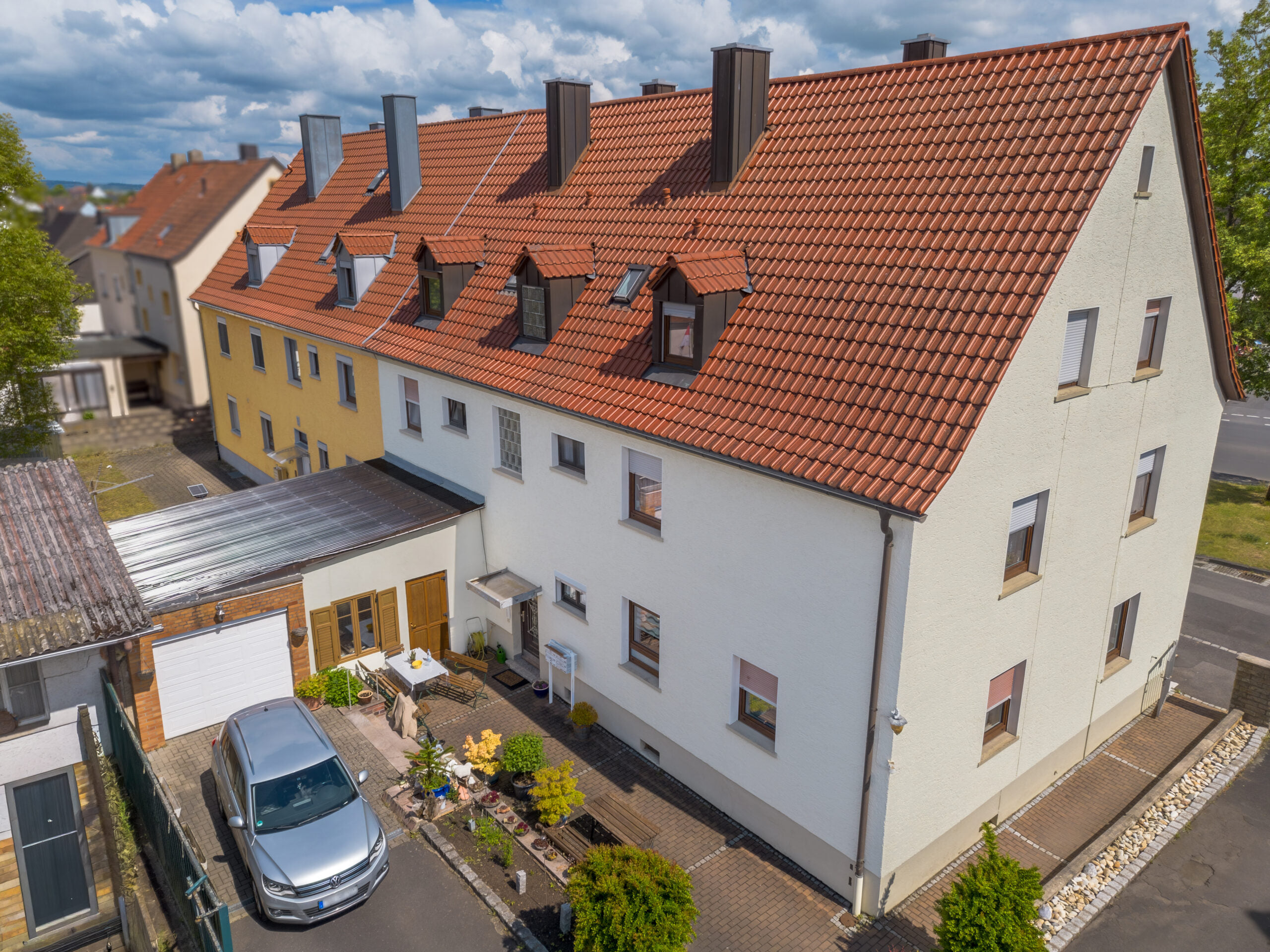 Drohnenaufnahme eines Wohnhauses mit Garten und Nebengebäuden