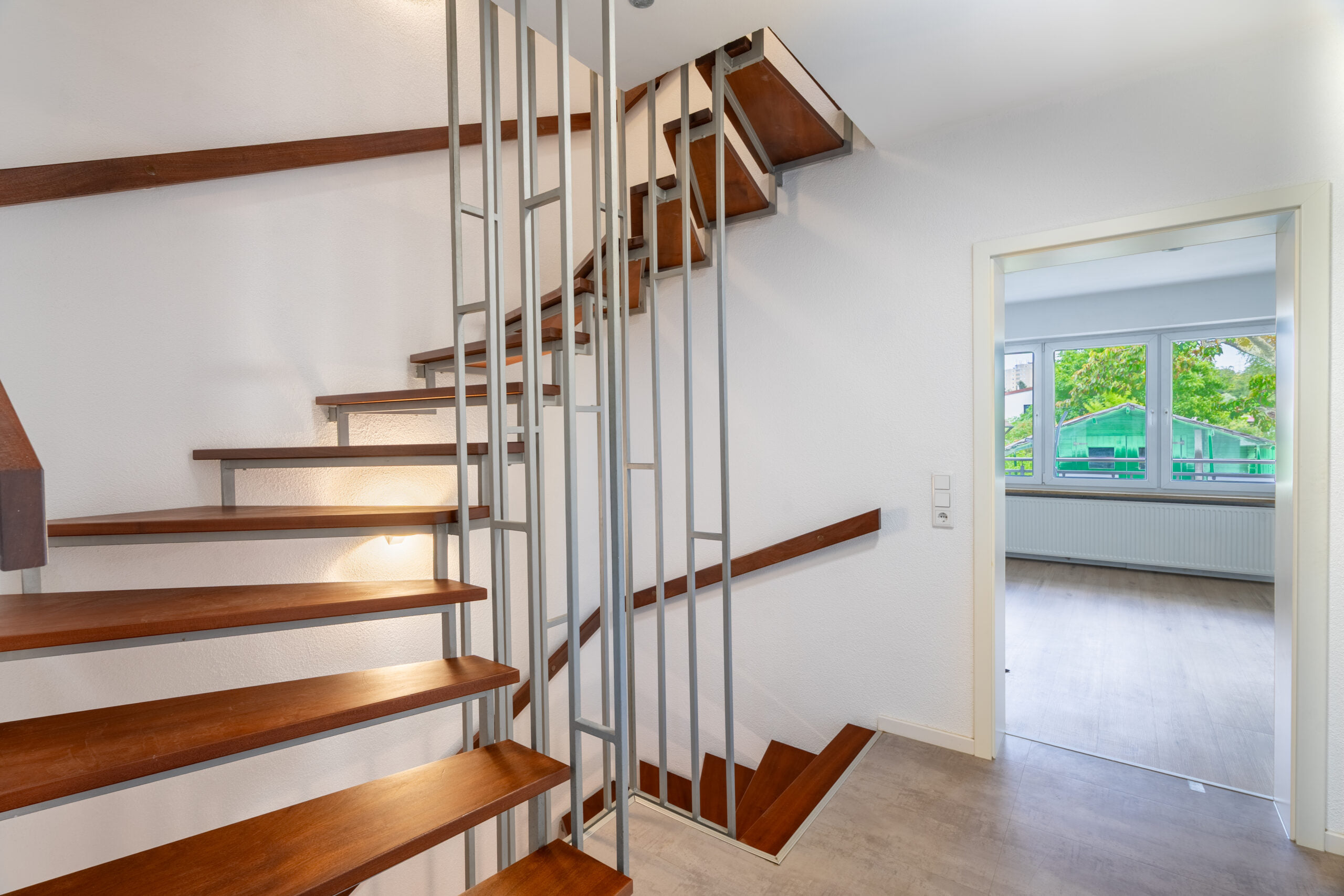 Flur mit hölzerner Treppe und Zugang zu weiteren Räumen