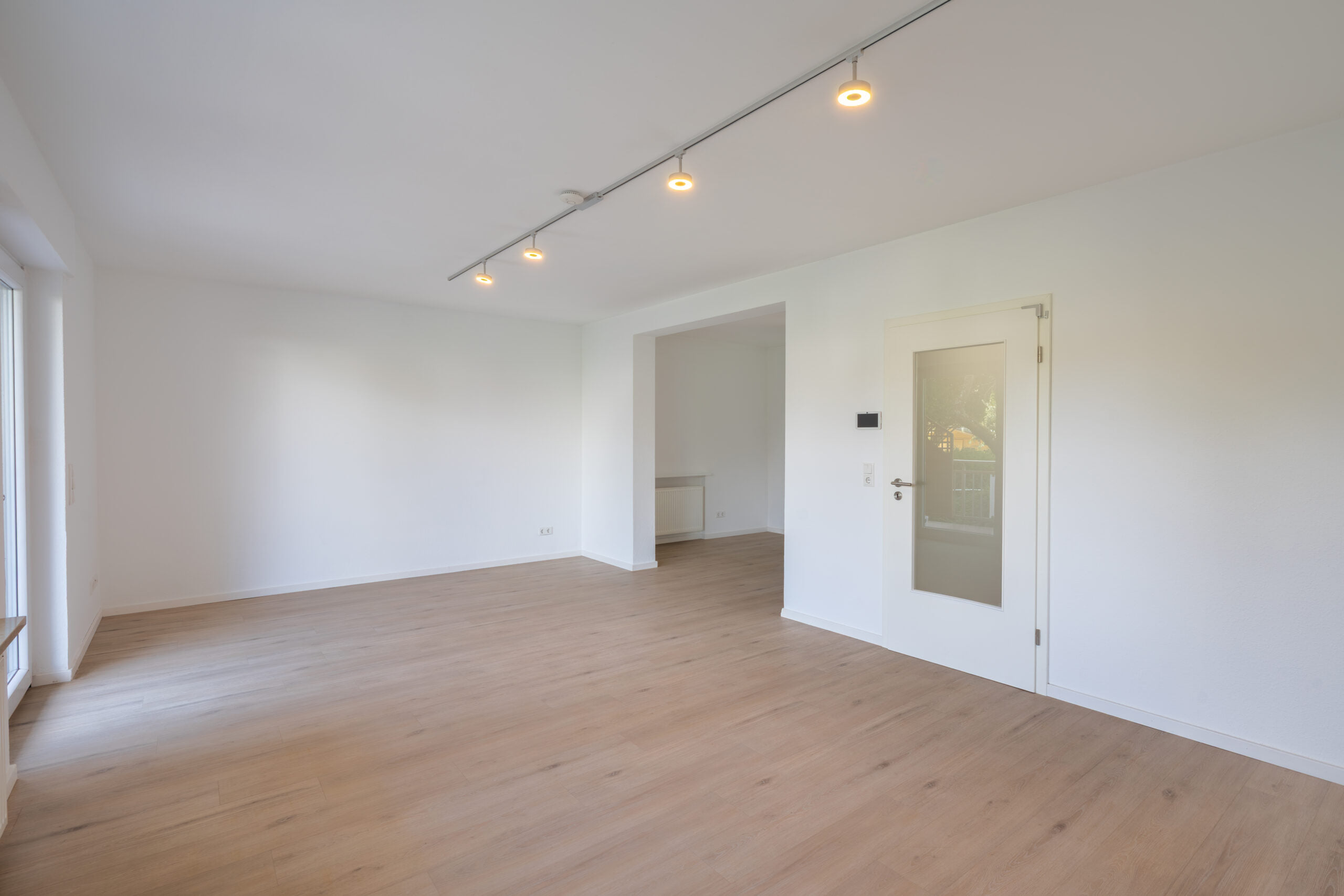 Leeres Wohnzimmer mit weißen Wänden und Einbaustrahlern