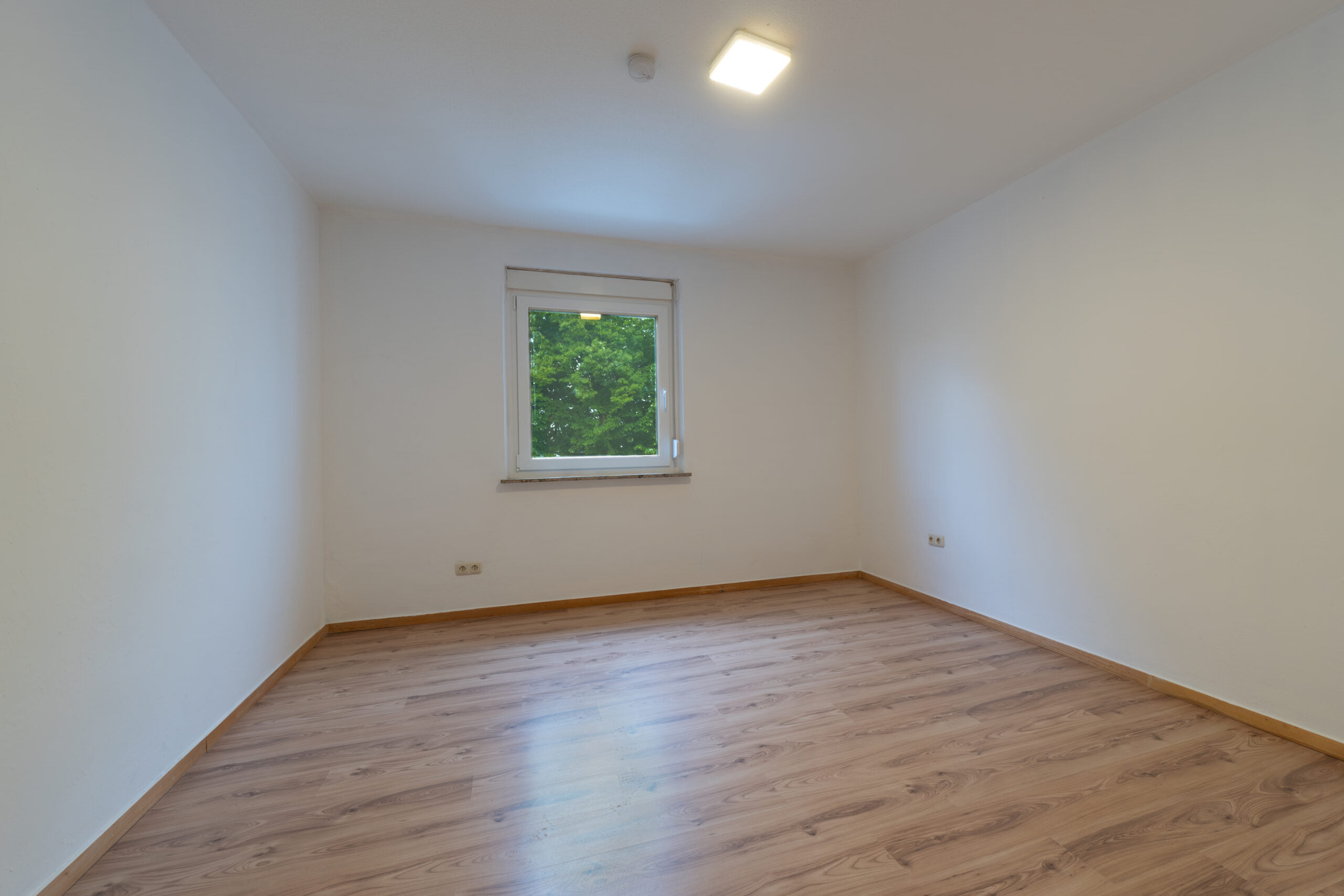 Leerer Raum mit Holzfußboden und Fenster